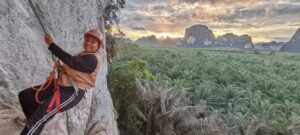 Traveler rock climbing in Ao Luek with safety gear