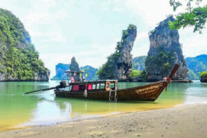 Boat on turquoise water near Laem Sak island at sunset